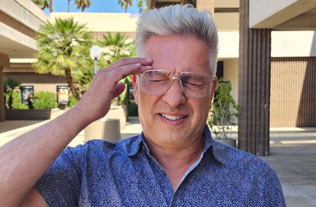 Adult wearing wire-frame glasses experiencing eye strain from an outdated prescription